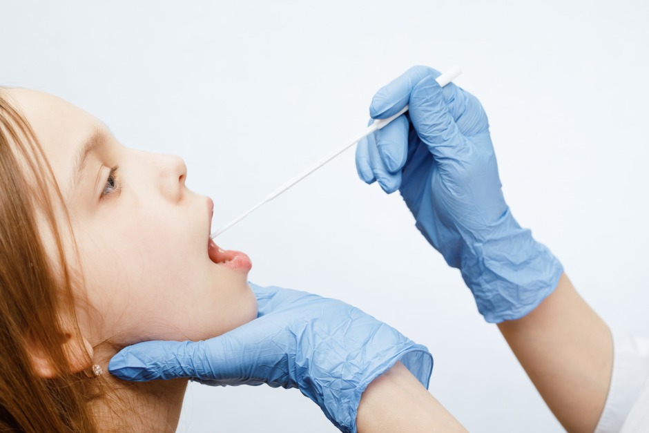 A young child having a saliva test done