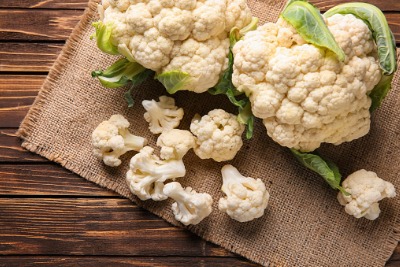 Fresh cauliflower and pieces on a hessian mat