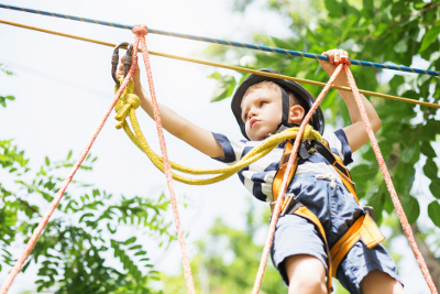 Image of small boy wearing helmet on rope course