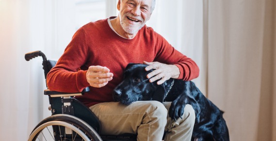 Man in a wheelchair with a black dog