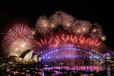 Fireworks erupting over Sydney Harbour Bridge and sails of the Sydney Opera House