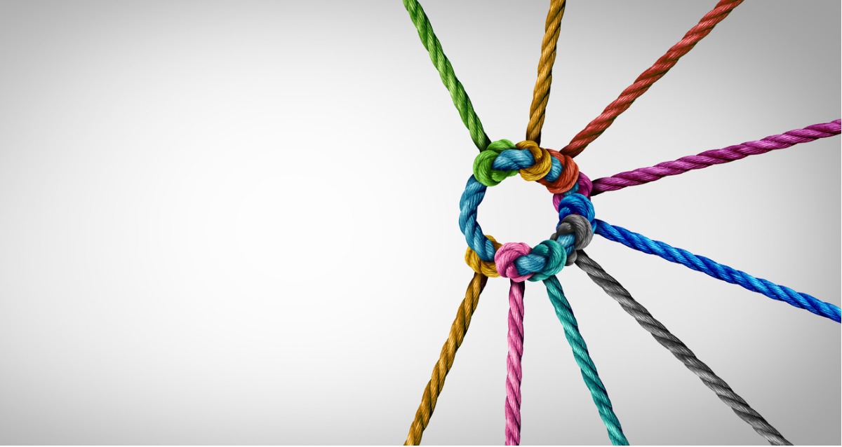An image of ropes, each a different colour. ties to a central rope that links them all. Concept photo of diversity and connections.