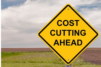 Image of road sign which reads "Cost cutting ahead"