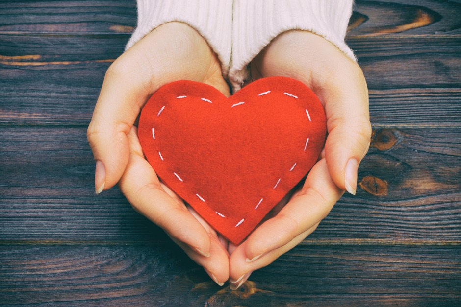 woman holding stitched heart in her hands